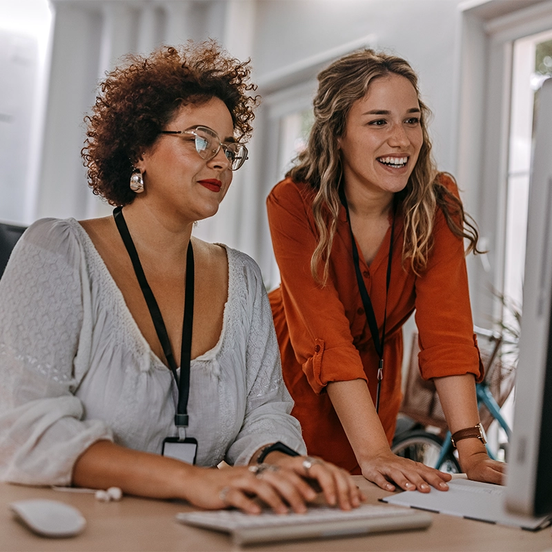 Women at an office looking at a computer together